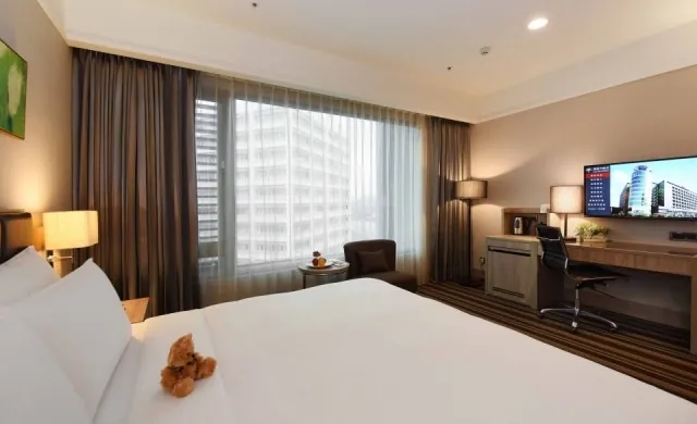 A king room at Fullon Hotel A8 with a large window over the city.
