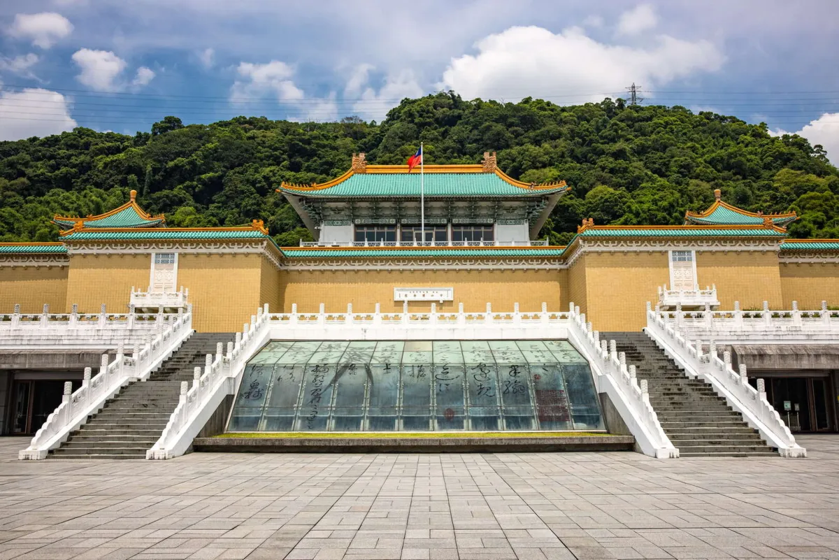 The National Palace Museum's classical Chinese-style white building set among lush green hills in Taipei.